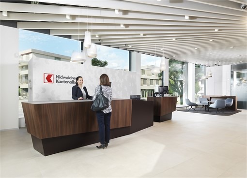 Empfangsbereich der Nidwaldner Kantonalbank mit zwei Damen, die eine Beratung fürhen für die Pressemitteilung über den neuen Kunden von Calenos.